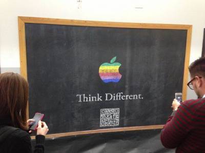 Учител нарисува логото на Apple и QR код с послание към учениците
