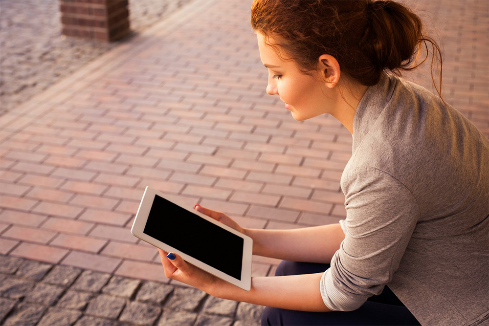 seated woman holding tablet